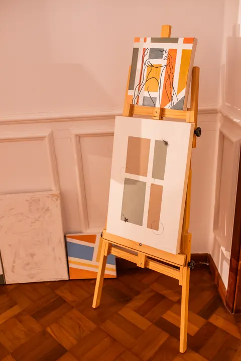 Cavalete de madeira com telas abstratas na galeria de arte, cenário para ensaios criativos