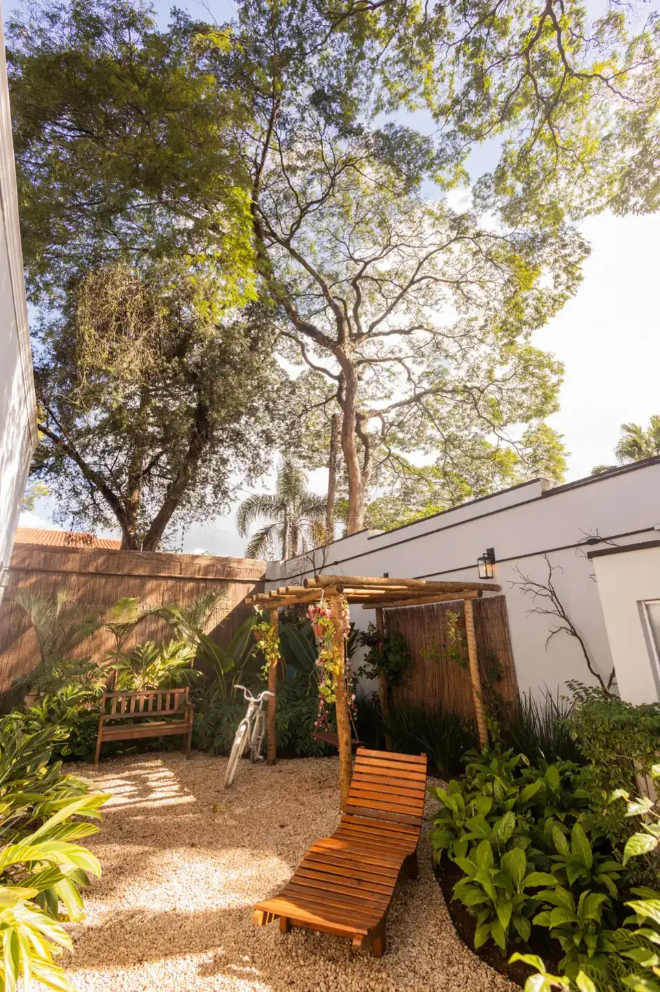 Jardim da Mansão Eventual com pergolado e árvores, área externa da casa para produções