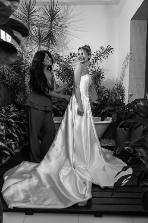 Foto em preto e branco da noiva de costas, com a cauda do vestido aberta