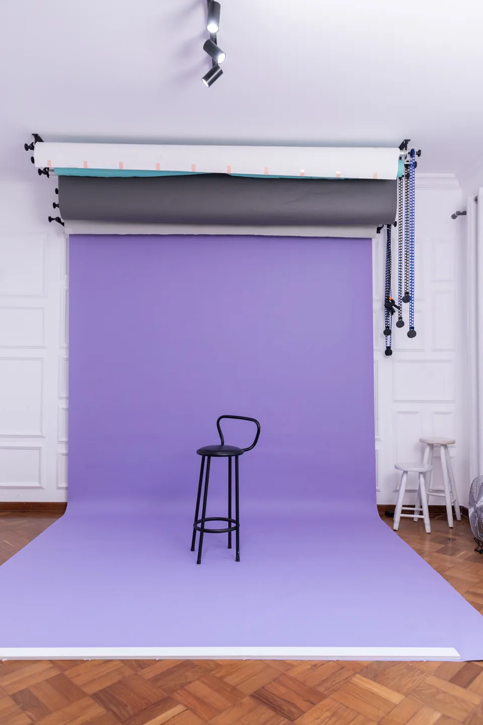 Fundo infinito lilás com banqueta de bar e banquetas brancas